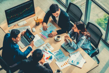 group of people in a conference room going over paperwork