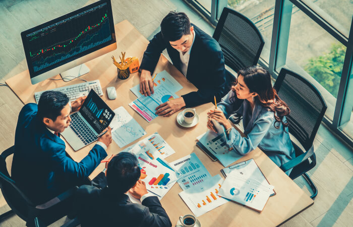 group of people in a conference room going over paperwork